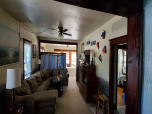 ein Wohnzimmer mit einem Sofa und einem Deckenventilator in der Unterkunft Quaint House Steps To The Beach With Great Backyard Space For Outside Dining in Surf City