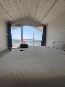 een slaapkamer met een groot bed en uitzicht op het strand bij Palolem Beach View Inn in Palolem
