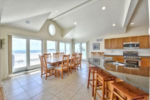 een keuken met een tafel, stoelen en ramen bij Spectacular Views Surf City Ocean Front With 6 Bedrooms, Great Beach!! in Surf City