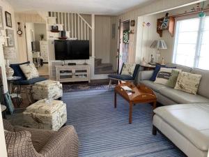 sala de estar con sofá y TV en Lovely Cape 5 Homes To The Beach, en Brant Beach