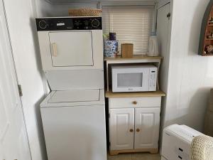 una pequeña cocina con microondas y nevera. en 2 Bedroom 1st Floor Apartment, Short Walk To Beach, en Surf City
