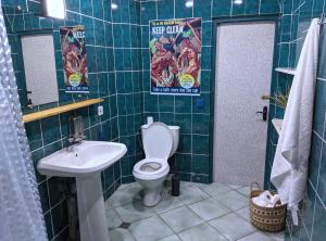 La salle de bains est pourvue de toilettes et d'un lavabo. dans l'établissement Palm Hostel, à Batoumi