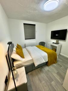 um quarto com uma cama grande e uma televisão de ecrã plano em Ensuite Luxury Bedroom In Purfleet em Purfleet