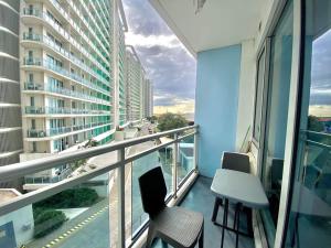 a balcony with two chairs and a table on a building at Azure Condo in Manila