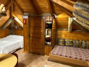 a bedroom in a log cabin with a bed and a mirror at Ο Σκίουρος Παραδοσιακοί Ξενώνες in Oíti