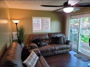 a brown leather couch in a living room with a window at Mountain View Lodging Cody in Cody