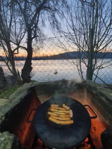 a grill with a bunch of food on it next to the water at Vikendica DRINSKI DAR in Mali Zvornik