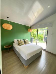 ein Schlafzimmer mit einem Bett und einer grünen Wand in der Unterkunft La mesa cundinamarca in La Mesa