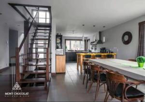 cocina y comedor con mesa larga y sillas en Villa Mont Chocolat, en Saint-Philémon
