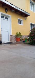 una casa gialla con una porta bianca del garage di CRISNANBEL a Las Grutas