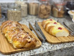 two cutting boards with bread and croissants on a counter at Hotel 7 Quedas in Guaíra