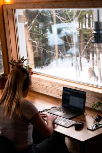 una mujer sentada en un escritorio con un ordenador portátil en Auberge Yoga Salamandre, en Lac-Brome