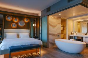 a bedroom with a large bed and a bath tub at Shade Hotel Manhattan Beach in Manhattan Beach