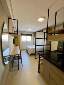 a room with a bed and a desk and a kitchen at Studio Moderno Westfit in Mossoró