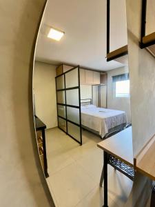 een kleine kamer met een bed en een spiegel bij Studio Moderno Westfit in Mossoró