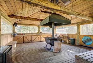 a large room with a stove in a wooden cabin at Charming Cabin in the Mountains-HOT TUB! in Nordegg