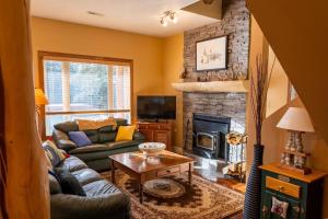 a living room with a couch and a fireplace at Charming Cabin in the Mountains-HOT TUB! in Nordegg