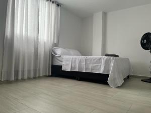 a room with a bed with a table and curtains at Apartamento Amoblado Pitalito in Pitalito