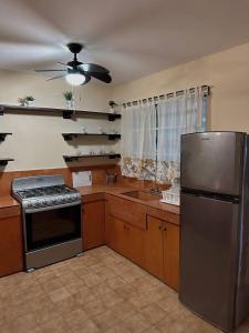 a kitchen with a stove and a refrigerator at La Casita de Jonas in Puerto Morelos