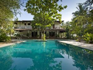 uma villa com piscina em frente a uma casa em Ocean's Edge em Tangalle