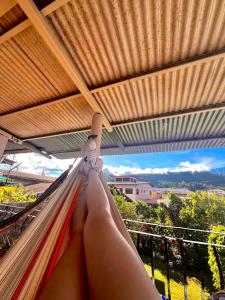 una mujer sentada en una hamaca en un balcón en Boho by Arte Hostal Boquete en Bajo Boquete