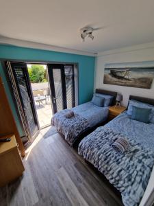 a bedroom with two beds and a sliding glass door at Seabreeze The Annexe in Blackpool