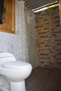 a bathroom with a white toilet and a shower at San José Tatacoa in Villavieja