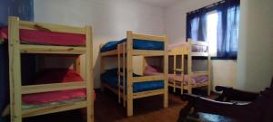 a room with three bunk beds in a room at Maui Hostel in Mar del Plata