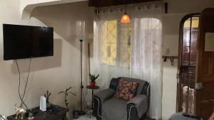 ein Wohnzimmer mit einem Stuhl und einem TV in der Unterkunft Paraiso Tropical in Liberia