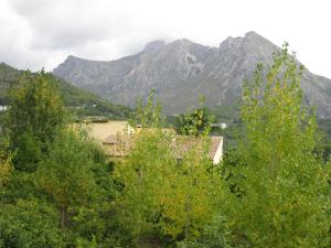 ein Haus mit Bergen im Hintergrund mit Bäumen in der Unterkunft Casa Rural Planet in Bolulla