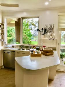 uma cozinha com um lavatório e uma grande janela em Boutique LUXE HomeStay Stunning VIEWS ! Villa em Orbost