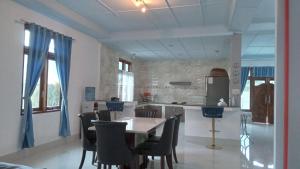 a kitchen with a table and chairs in a room at Alice Villa2 in Tuktuk Siadong