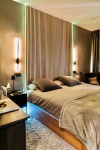 Un dormitorio con una cama grande con cabecero de madera. en Luxury and elegant apartment Madrid, en Madrid