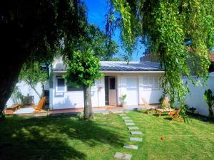 ein weißes Haus mit einem Baum im Hof in der Unterkunft Dpto tipo cabaña a 3 cuadras del mar in Mar del Plata
