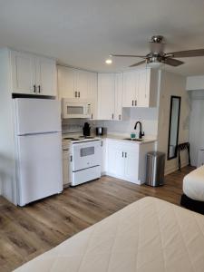 a kitchen with white cabinets and a white refrigerator at Devon Shores in Clearwater Beach