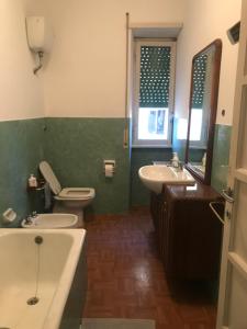 a bathroom with a toilet and a sink and a tub at Villa Fiorelli rooms in Rome