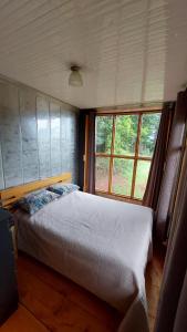 a bedroom with a bed and a large window at Monte Armadillo in Poás