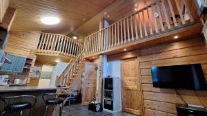 a kitchen and a living room with wooden walls at Tahko Villa Vaarna in Tahkovuori