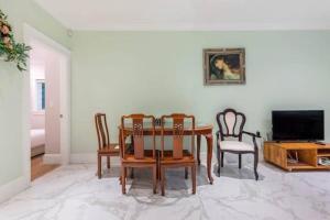 a dining room with a table and chairs and a television at 温哥华中心的舒适宁静独立出入2房1卫休闲体验 in Vancouver