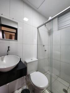 La salle de bains blanche est pourvue de toilettes et d'un lavabo. dans l'établissement Unidade Frida Kahlo - Apto próximo ao HC/USP, à Ribeirão Preto