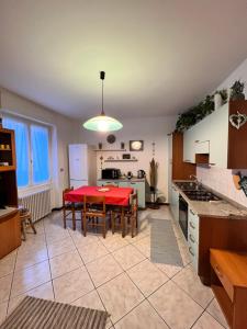 a kitchen with a red table in the middle of a room at VALTELLINA SONDRIO HOLIDAYS in Sondrio