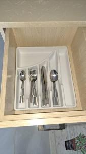 a white tray with silver utensils in a cabinet at Bahia 128 in Discovery Bay