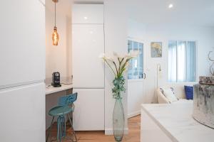 a white kitchen with a vase with flowers in it at Le Sapphire in Toulouse +20 photos
