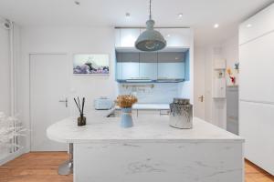 a white kitchen with a large white counter top at Le Sapphire in Toulouse