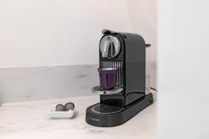a black coffee maker with a purple drink at Le Sapphire in Toulouse