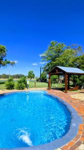 uma grande piscina com um gazebo em Australian Homestead Motor Lodge em Wagga Wagga