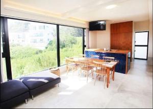a kitchen and dining room with a table and chairs at senahahausub03 in Yomitan