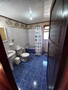 Un baño con inodoro, lavabo y bañera. en Cabaña Martina, en Pucón