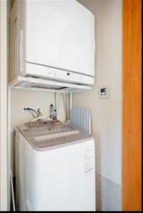 讀谷的住宿－senahahausub03，厨房配有水槽和冰箱上方的微波炉