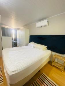 邦比尼亞斯的住宿－Casa na praia de bombas，一间卧室配有一张白色的床和蓝色床头板